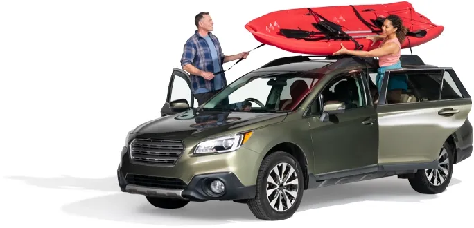 A couple secure a red raft atop their SUV